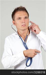 Young man examining his own heart with a stethoscope