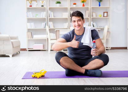 Young man exercising at home in sports and healthy lifestyle concept. Young man exercising at home in sports and healthy lifestyle con