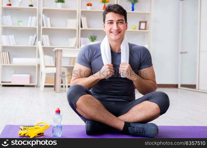 Young man exercising at home in sports and healthy lifestyle concept. Young man exercising at home in sports and healthy lifestyle con