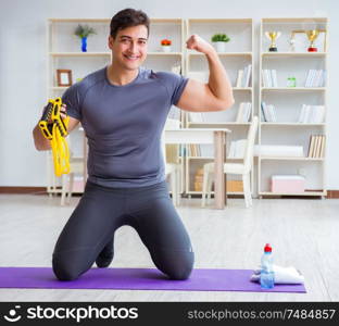 Young man exercising at home in sports and healthy lifestyle concept. Young man exercising at home in sports and healthy lifestyle con