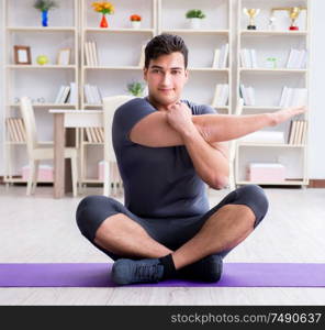 Young man exercising at home in sports and healthy lifestyle concept. Young man exercising at home in sports and healthy lifestyle con