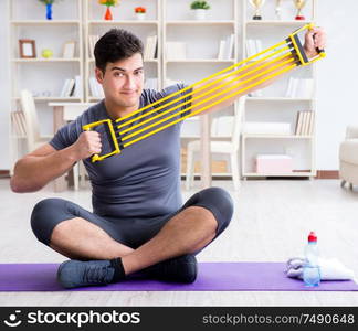 Young man exercising at home in sports and healthy lifestyle concept. Young man exercising at home in sports and healthy lifestyle con