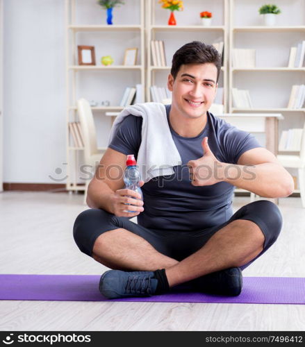 Young man exercising at home in sports and healthy lifestyle concept. Young man exercising at home in sports and healthy lifestyle con