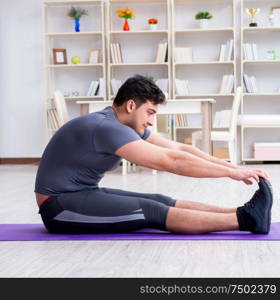 Young man exercising at home in sports and healthy lifestyle concept. Young man exercising at home in sports and healthy lifestyle con