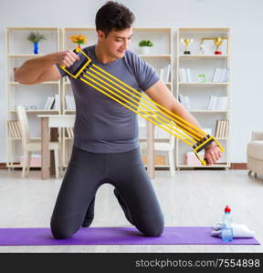 Young man exercising at home in sports and healthy lifestyle concept. Young man exercising at home in sports and healthy lifestyle con