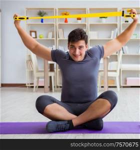 Young man exercising at home in sports and healthy lifestyle concept. Young man exercising at home in sports and healthy lifestyle con