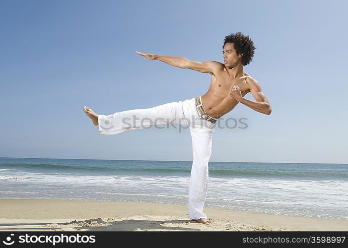 Young man exercising on beach