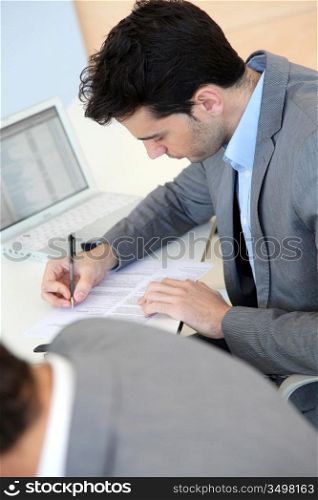 Young man filling in application form