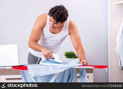 Young man freelancer ironing in the bedroom 