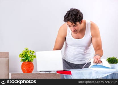 Young man freelancer ironing in the bedroom 