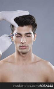 Young man getting botox injection
