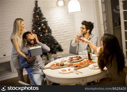 Young man getting present from loving woman for Christmas or New Year Eve