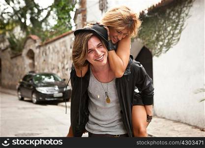 Young man giving girlfriend a piggyback on street, Rio De Janeiro, Brazil