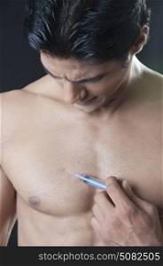 Young man giving himself an injection