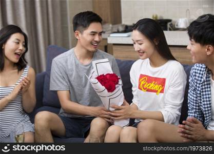 Young man giving his girlfriend flowers