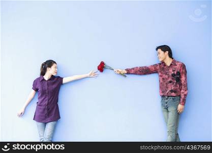 Young man giving roses to a young woman