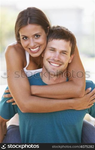 Young Man Giving Woman Piggyback Outdoors