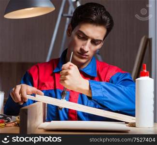 Young man gluing wood pieces together in DIY concept. The young man gluing wood pieces together in diy concept