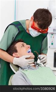 Young man going through therapy of tooth in clinic