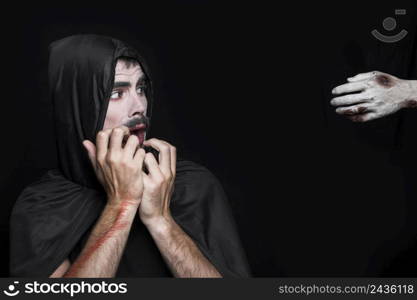 young man halloween costume looking corpse hand