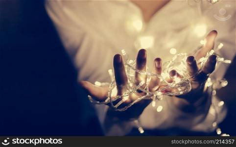 Young man hand holding beautiful light in the dark, retro image style