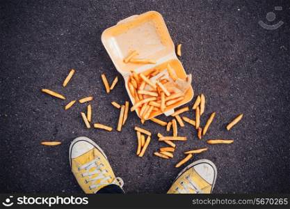 Young man has dropped his chips in the street