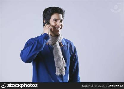 Young man having conversation on mobile phone and looking away