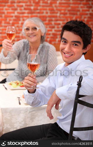 Young man having dinner with his grandmother