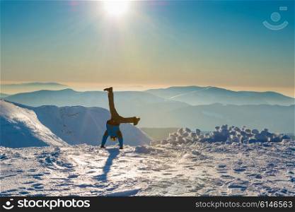 Young man having fun on the snow in the mountains