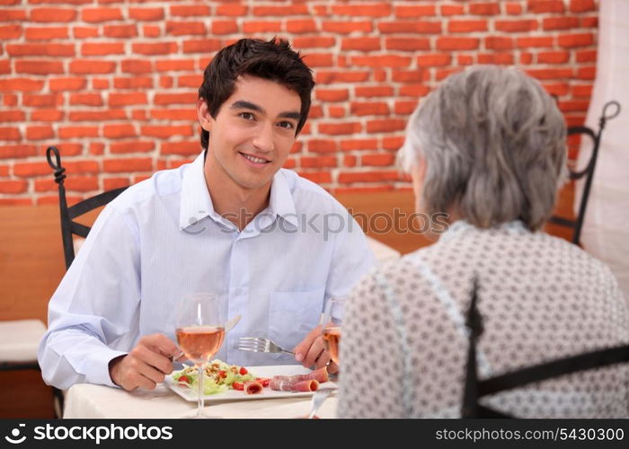 young man having lunch with his grandmother