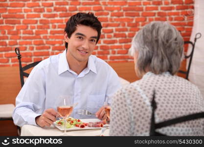 young man having lunch with his grandmother