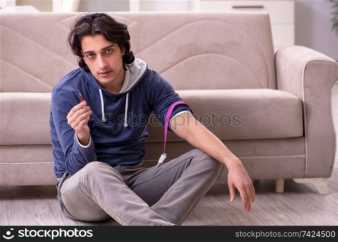 Young man having problems with narcotics at home 