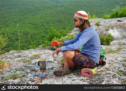 Young man having rest at the top of mountain