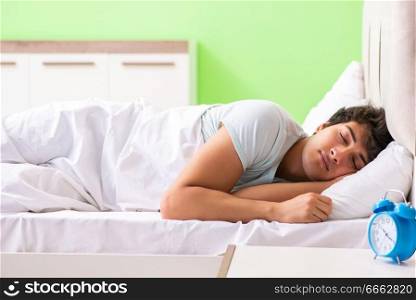 Young man having trouble waking up in early morning