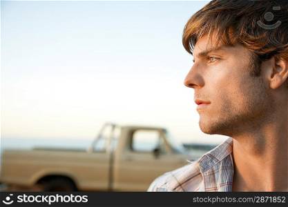 Young man head and shoulders profile in front of van