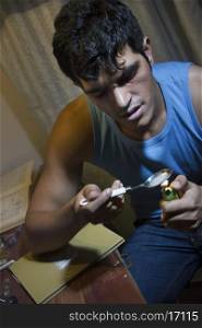 Young man heating drugs in spoon with lighter