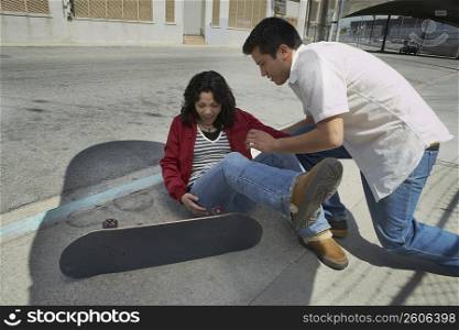 Young man helping a young woman to stand up