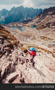 Young man hiking alone along a rocky trail in the mountains