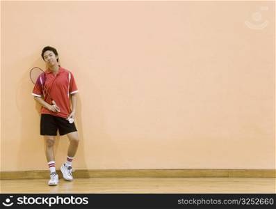Young man holding a badminton racket and a shuttlecock