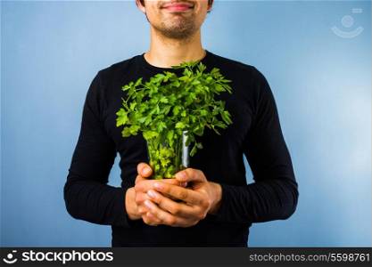 Young man holding a bunch of parsley