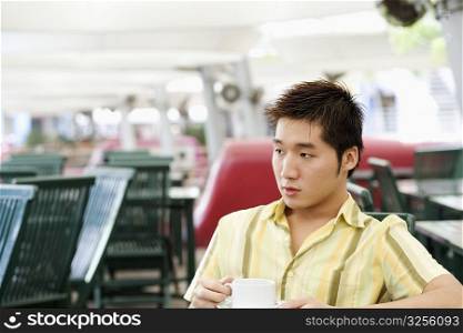 Young man holding a cup of coffee