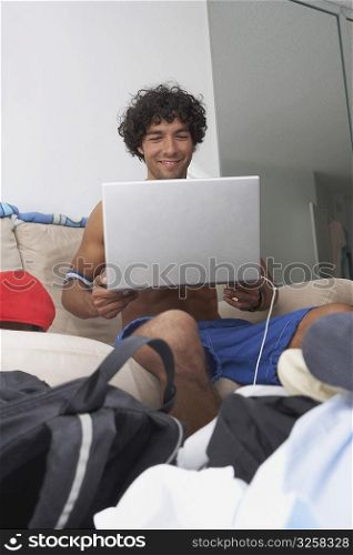 Young man holding a laptop and smiling