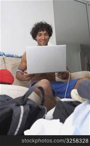 Young man holding a laptop and smiling