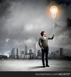 Young man holding a light. Young man holding a light at his hands against polluted and ruined landscape