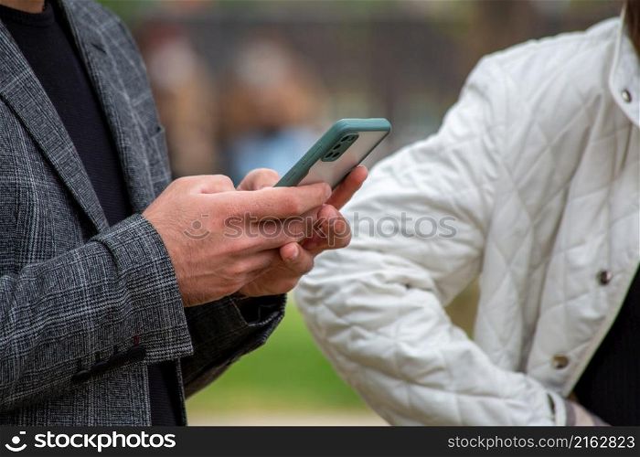 Young man holding a mobile phone. Looking at the phone.