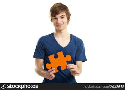 Young man holding a puzzle piece isolated on white background, soluton concept