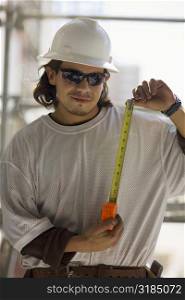 Young man holding a tape measure