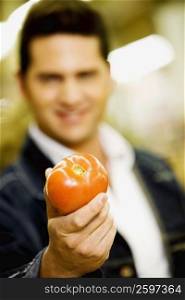 Young man holding a tomato