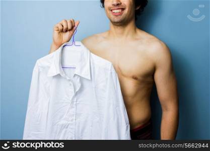 Young man holding a white shirt