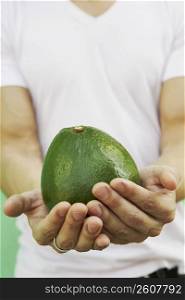 Young man holding an avocado